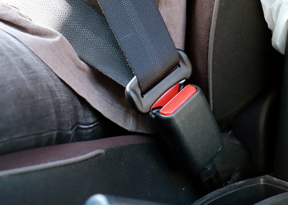 Automotive seat belt webbing latched into a buckle on a vehicle seat